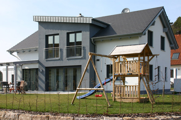 Moderner Neubau eines Einfamilienhauses mit Erker und schräg gestellter Schleppgaube.